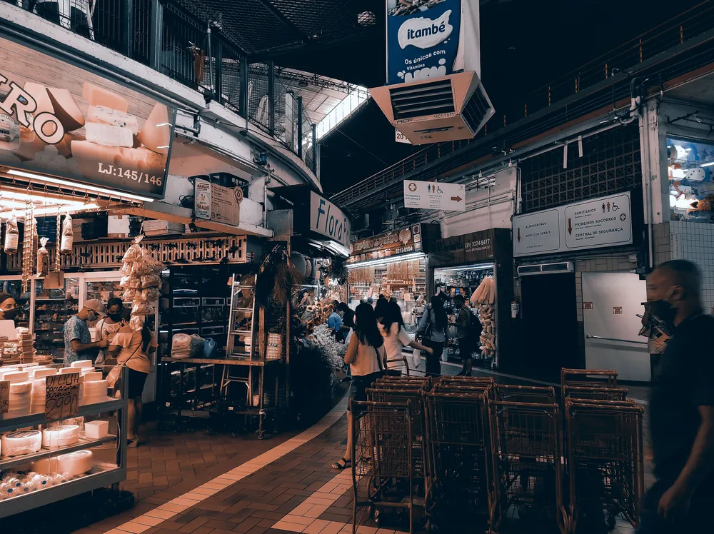 An indoor street food market with a stall displaying various food